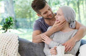 a man holding a woman who has gone through chemo