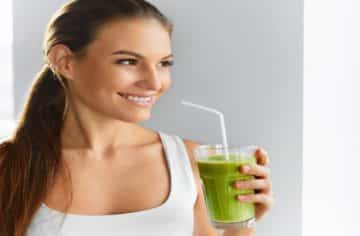 woman drinking a green smoothie