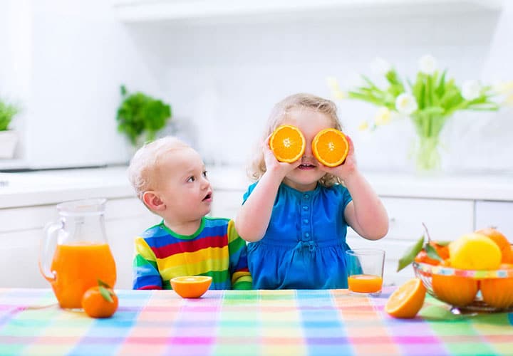 a girl with oranges over her eyes